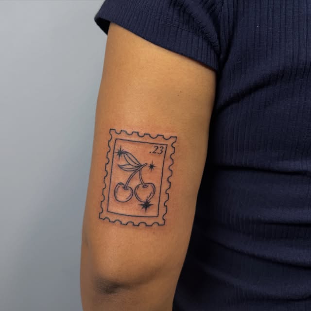Fine line cherries inside a postage stamp frame on the back of the arm